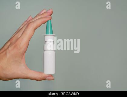 Un spray nasal dans la main d'une femme gros plan. Bannière d'arrière-plan avec espace de copie pour le texte. Banque D'Images
