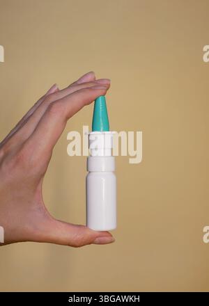 Un spray nasal dans la main d'une femme gros plan. Banque D'Images