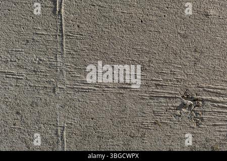 Texture de béton rugueux présentant des détails de surface, des motifs naturels et des matériaux de conception. Le gros plan souligne la robustesse et les tons terreux. Banque D'Images