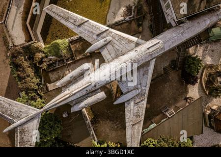 Vue aérienne d'un avion altéré et en décomposition reposant sur le sol dans une zone urbaine abandonnée Banque D'Images