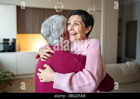 Femme âgée excitée embrassant son mari heureux. Célébrer les bonnes nouvelles, le bonheur partagé, la famille aimante Banque D'Images