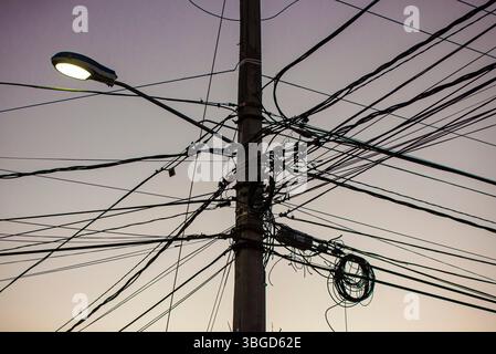 Bayahibe, République dominicaine 1er janvier 2025 : enchevêtrement de fils électriques et de communication créant un chaos visuel sur un poteau électrique à dominicus Or Banque D'Images