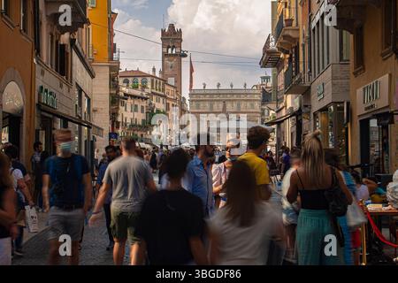 Vérone, Italie 1er janvier 2025 : touristes marchant dans la via mazzini, une rue commerçante piétonne dans le centre historique de vérone, en italie Banque D'Images