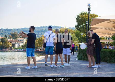 Lac de Garde, Italie 3 janvier 2025 : touristes prenant des photos et profitant de la vue panoramique sur le lac de garde à bardolino, italie, par une journée ensoleillée Banque D'Images