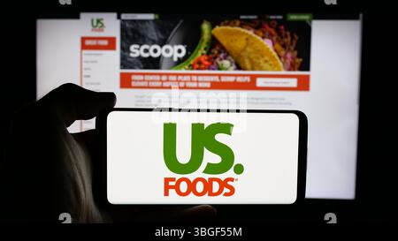 Stuttgart, Allemagne - 01 31 2025 : personne tenant un téléphone portable avec le logo de la société de services alimentaires US Foods Holding Corp. sur l'écran Banque D'Images