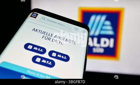 Stuttgart, Allemagne - 03-13-2025 : téléphone portable avec le site Web de la société allemande ALDI SUD sur l'écran devant le logo de l'entreprise. Banque D'Images