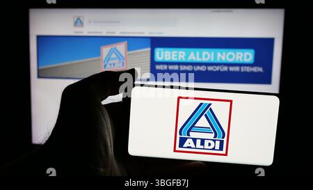 Stuttgart, Allemagne - 03-13-2025 : personne tenant un téléphone portable avec le logo de la société allemande ALDI Nord Deutschland Stiftung Co. KG à l'écran Banque D'Images