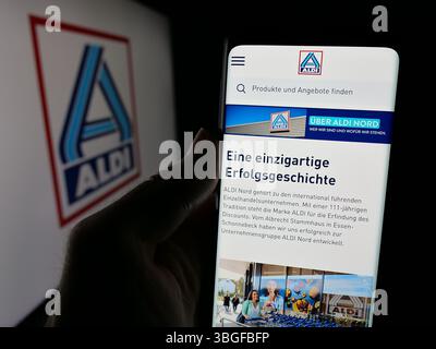 Stuttgart, Allemagne - 03-13-2025 : personne tenant un smartphone avec le site web de la société allemande ALDI Nord Deutschland Stiftung Co. KG à l'écran Banque D'Images