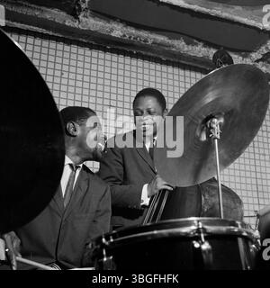 Der US-amerikanische Jazzschlagzeuger Buster Smith (vorn am Schlagzeug) und der bassiste George Joyner (im Hintergrund) BEI einem mitreißenden Live-Konzert in einem Club der 1960er Jahre. Beide Musiker sind im moment des Spiels vertieft, die Energie des Jazz ist spürbar. Banque D'Images