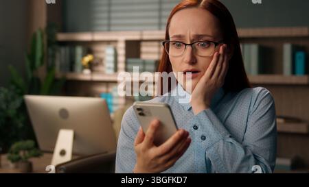 Femme stressée fille caucasienne bouleversée bureau de travailleuse d'affaires frustré tenant téléphone portable échec problème mauvaises nouvelles négatives inquiet triste trouble Banque D'Images