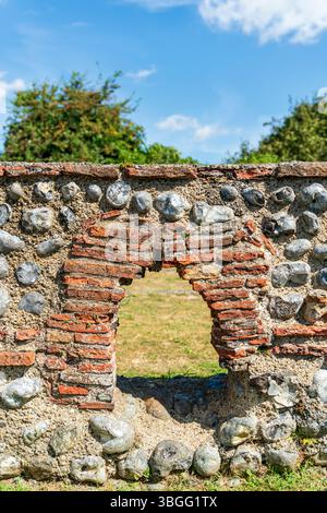 Petite arche dans les vestiges des murs de pierre de la maison de bains du IIIe siècle au château romain de Richborough. Pierres avec tuiles rouges composant l'arche, Banque D'Images