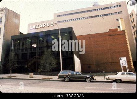 Cette photographie de 1980 capture une partie du grand magasin Lazarus au 141 South High Street, vue depuis West Town Street. L’image montre également les châteaux d’eau proéminents du magasin et, au premier plan, un bâtiment vitré qui deviendrait le restaurant Ho-Toy, 11 West Town Street. Banque D'Images