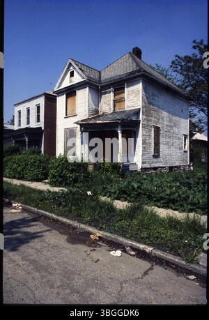 La diapositive représente une maison vacante et abandonnée de deux étages encadrée en bois avec des fenêtres cassées. La maison est embarquée et située dans une zone non spécifiée. Banque D'Images