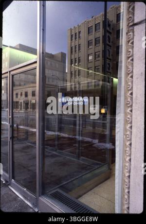 Cette photographie de 1980 montre l'entrée en verre de l'immeuble Columbia Gas of Ohio au 99 North Front Street. Un reflet du signe Hertz du garage de stationnement est visible dans la vitre. Banque D'Images