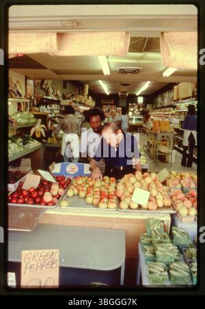 Dans le magasin de fruits Cappy Brothers and sons, deux hommes examinent les produits. Situé dans le centre-ville de Columbus, Ohio, le marché, également connu sous le nom de Cappy's fruit Market et Cappy's Market and Delicatessen, offrait une variété de viandes, de fruits et de produits. Banque D'Images