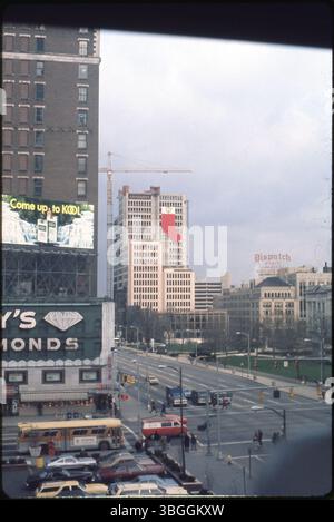 Photographiée vers décembre 1975 depuis Broad and High Streets, cette vue montre la tour de bureaux BancOhio National Plaza s'élevant au centre-ville avec un bas de Noël rouge et blanc géant fixé à la façade inachevée. Une grue de construction se tient au-dessus du châssis en acier. Le siège social de la banque de 31 étages a ouvert le 12 juin 1976 ; le panneau Roy’s Diamonds et le bâtiment Columbus Dispatch au 34 South Third Street apparaissent au premier plan. Banque D'Images