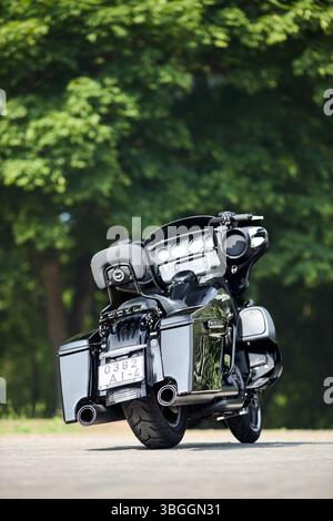 Minsk, Biélorussie - 4 juin 2025 : Harley-Davidson HD Street Glide Twin Cam 103 Motorcycle Selective Focus sur fond de feuillage vert vertical Banque D'Images