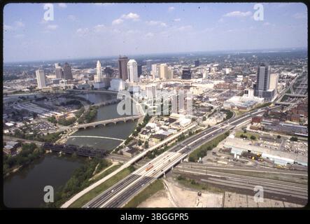 Cette vue aérienne du centre-ville de Columbus en 1991 montre la rivière Scioto courbant autour de la péninsule de Scioto. Les principales caractéristiques comprennent Town Street et main Street Bridges, Central High School, Waterford Tower Condominiums et le Columbia Gas Building. Banque D'Images