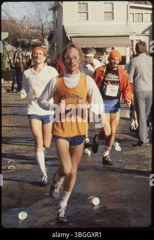 Gros plan des coureurs et des spectateurs d'un marathon à une station d'eau sur East Dodridge Street et Findley Avenue pendant le marathon Columbus Bank One en 1980. Le marathon a commencé en 1978 et a été connu sous le nom de Columbus Bank One Marathon jusqu'en 1984. Il est maintenant appelé le Nationwide Children's Hospital Columbus Marathon. Banque D'Images
