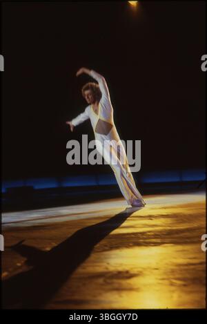 Un patineur artistique masculin en costume blanc se produit sur la glace pendant les Ice Follies et Holiday on Ice 1980 au Ohio State Fairgrounds Coliseum. L'événement mettait en vedette des patineurs médaillés olympiques, des costumes extravagants et des apparitions de personnages de la rue sésame. Banque D'Images