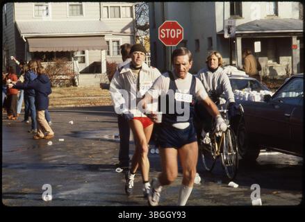 Cycliste suit le coureur de marathon #2450 à une station d'eau située sur Findley Avenue et East Dodridge Street pendant le Columbus Bank One Marathon en 1980. Le marathon, qui a commencé en 1978, a été rebaptisé le Nationwide Children's Hospital Columbus Marathon. Banque D'Images