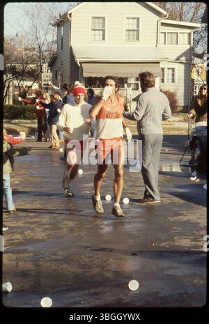Les participants au marathon de Columbus de 1980 traversent un quartier de Columbus, avec des spectateurs acclamés depuis les lignes de touche. L'événement, qui a débuté en 1978, était à l'origine connu sous le nom de Bank One Marathon. Banque D'Images