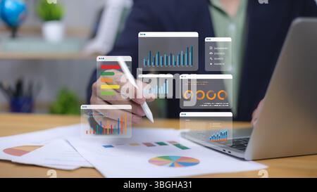 Human utilise un stylo interagissant avec des analyses et des rapports commerciaux numériques. Symbolise la visualisation des données, la performance financière, la décision stratégique-makin Banque D'Images