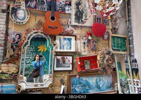 Femme réfléchie dans le miroir tout en prenant une photo d'une curieuse façade avec des œuvres d'art et des meubles assortis à Palerme, Sicile Banque D'Images