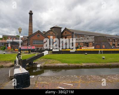 Port d'Ellesmere, Cheshire, Royaume-Uni, 05-31-2025, musée national des voies navigables. Bâtiments industriels historiques avec écluse de canal sous un ciel nuageux. Banque D'Images
