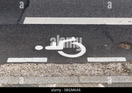 Le parking est réservé aux conducteurs handicapés uniquement. Panneau d'indication de stationnement pour véhicules pour personnes handicapées peinture sur route, texture du panneau de transport Banque D'Images