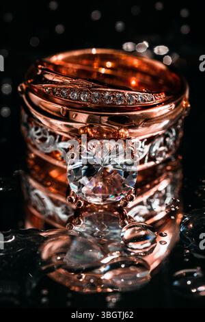 Bague en or solitaire élégante ornée de diamants reposant sur une surface noire élégante, symbolisant romance, prestige, proposition ou accessoires haut de gamme. Banque D'Images