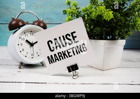 Cause Marketing texte écrit sur carte papier avec réveil sur fond en bois Banque D'Images