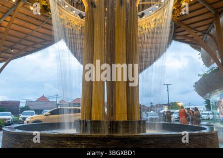 Bali, Indonésie - 17 décembre 2024 : Icon Bali Mall à Bali. Grand arbre avec une fontaine au milieu. La fontaine pulvérise de l'eau. La scène est p. Banque D'Images