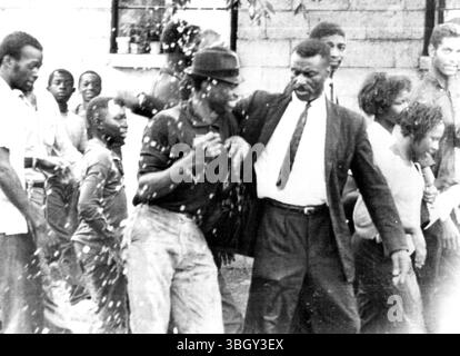 Le révérend Fred Shuttlesworth (à droite, à l'avant) gifle un jeune homme avec un chiffon humide pour avoir raillé la police lors d'une manifestation raciale, où la police et les pompiers ont utilisé des tuyaux à haute pression et une voiture blindée comme « contrôle de la foule ». 7 mai 1963 Banque D'Images