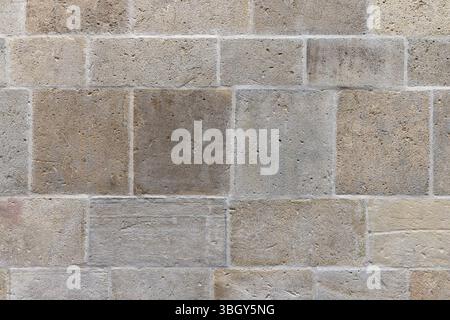 Texture de mur de brique de pierre rustique avec tons neutres terrestres et surface rugueuse. Photo de fond abstraite Banque D'Images