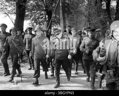Des contacts fermes ont été établis entre les forces terrestres de la première armée américaine et celles de l'armée russe. La rencontre historique a eu lieu à 16 heures le 26 avril , dans la ville de Torgau , sur l'Elbe - à 75 miles de Berlin - lorsque les troupes de la première Armée rencontrèrent des éléments avancés de la Division de la Garde russe . Photos : le général de division Emil F Reinhardt , commandant général de la 69e division d'infanterie , vu ici marcher avec le général russe qui a effectué la liaison. 26 avril 1945 Banque D'Images