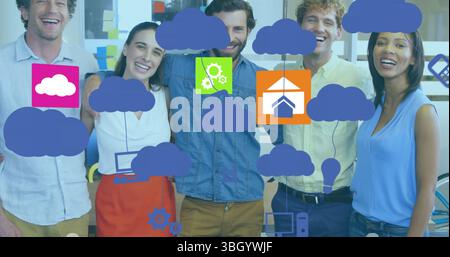 Image d'icônes technologiques et de nuages sur divers collègues féminins et masculins au bureau Banque D'Images