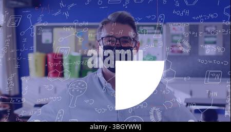 Enseignant portant un masque noir écrivant des formules chimiques sur un panneau transparent dans le laboratoire, avec des bacs de stockage Banque D'Images