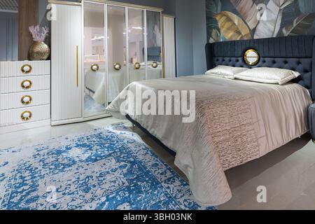 Intérieur de la chambre de luxe moderne avec armoire à miroirs et papier peint tropical Banque D'Images
