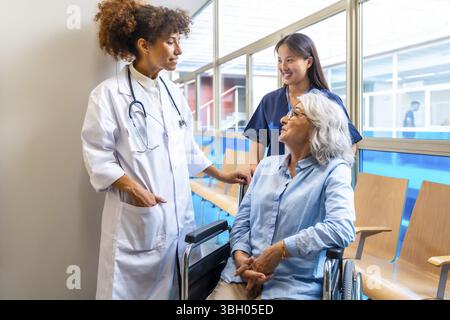Des professionnels de la santé dispensant des soins et un soutien à un patient âgé en fauteuil roulant, soulignant l’importance des soins de santé pour les personnes âgées Banque D'Images