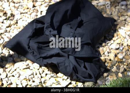 sac noir froissé sur le dessus des rochers Banque D'Images