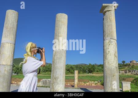 Les femmes de race blanche en photographiant un temple grec. Femme prend des photos de Doric Propylon entrée de l'ancienne Messène, site archéologique, Péloponnèse, Gree Banque D'Images