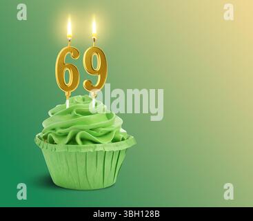 Délicieux cupcake avec des bougies en forme de nombre brûlant sur fond dégradé vert, espace pour le texte. 69e anniversaire ou autre occasion spéciale Banque D'Images