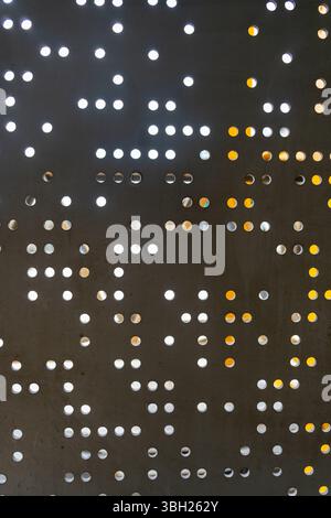 Motif de points noirs et blancs sur un mur. Les points sont disposés dans une grille, certains plus grands et d'autres plus petits. L'effet global est un peu abstra Banque D'Images