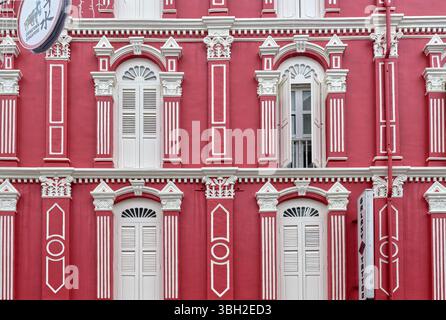 Une belle maison rose dans un style traditionnel, avec des fenêtres cintrées et en treillis, à Chinatown, Singapour Banque D'Images
