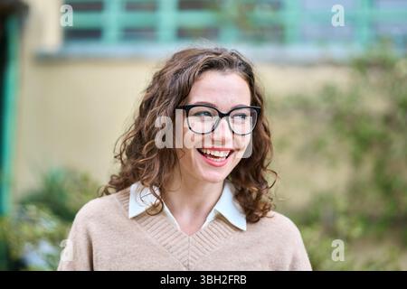 Jeune femme d'affaires professionnelle souriante debout à l'extérieur, portrait. Banque D'Images