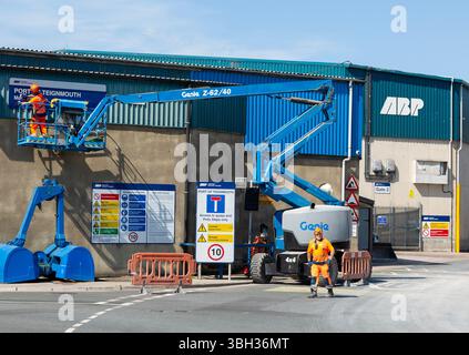 Homme sur le panneau de nettoyage de machines de cueillette de cerises, Port de Teignmouth, Teignmouth, sud du Devon, Angleterre, ROYAUME-UNI Banque D'Images