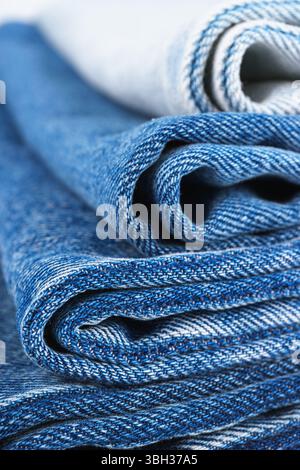 Pile de textiles pliés, différentes nuances de tissu de jeans bleu, tissu de denim, sont empilés les uns sur les autres dans le cadre du magasin, mettant en valeur différentes te Banque D'Images