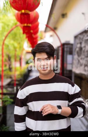 Jeune homme gay asiatique mignon dans le jardin zen de style chinois pendant la journée Banque D'Images