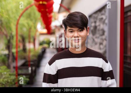 Jeune homme gay asiatique mignon dans le jardin zen de style chinois pendant la journée Banque D'Images